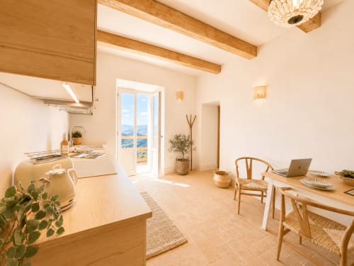 Bright Tuscan apartment kitchen and dining area with wooden beams, terrace access, and garden views at Montemassi townhouse