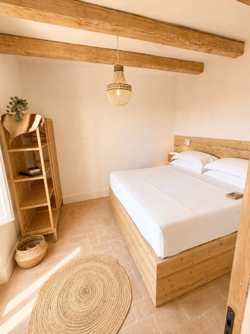 Rustic bedroom at Tuscan Townhouse with wooden beams, queen bed, beaded chandelier, and terracotta floors