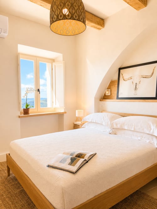 Bright bedroom in Tuscan Townhouse with wooden bed, mountain view window, and modern amenities