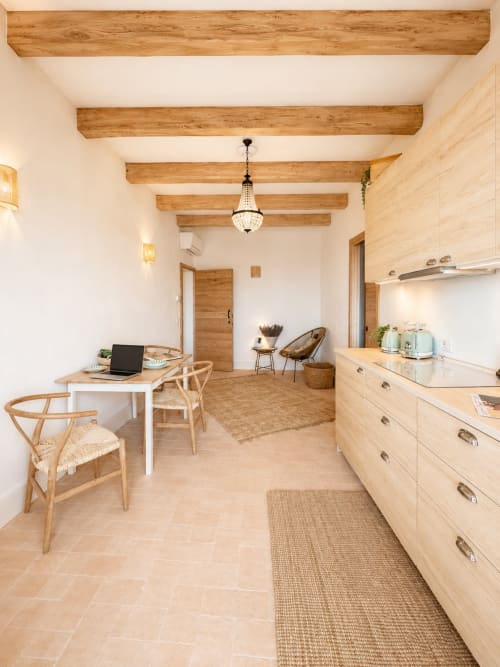 Tuscan Townhouse apartment in Montemassi with wooden beams, modern kitchen, workspace desk, and garden view seating area