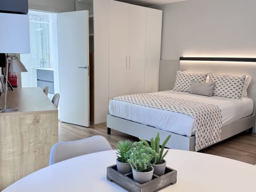 Appartement studio beige moderne au RIA CENTRUM Smart Residence à Aveiro avec lit queen-size, penderie, bureau et plantes en pot