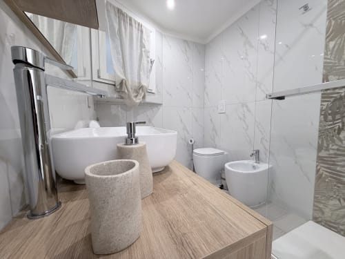 Bagno moderno della Suite Sabò nel Dream Suite Bologna con doppio lavabo, toilette, bidet e pareti rivestite in marmo