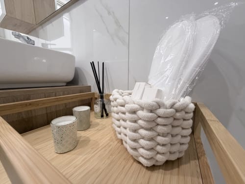 Lavabo del bagno di Dream Suite Bologna con cesto porta-asciugamani, articoli da toilette e specchio nella Sabò Double Room