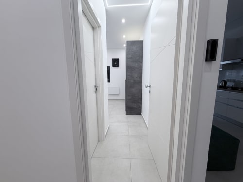 Corridoio moderno nella camera Lame di Dream Suite Bologna, con pareti bianche, pavimento in piastrelle grigie e scorcio di cucina scura