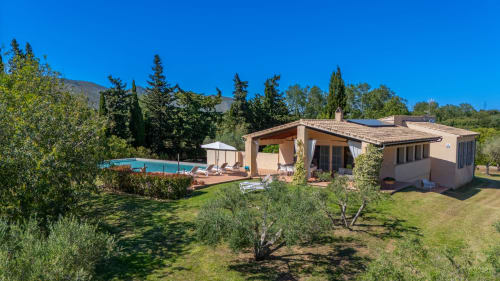 Villa toscana en Artà con piscina, arquitectura de terracota, olivares y jardines cuidados bajo cielo azul despejado