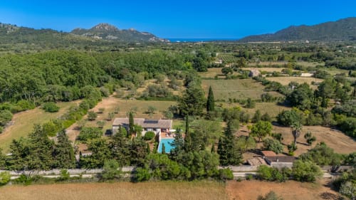 Vista aérea de villa de lujo con piscina en Artà, Mallorca rodeada de paisaje mediterráneo y montañas