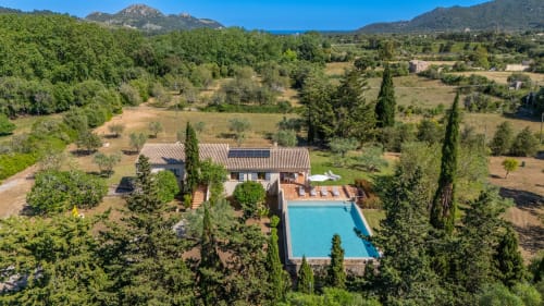 Hotel Massa Properties en Artà con piscina, edificio de terracota, cipreses y paisaje mallorquín circundante
