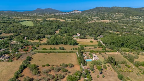 Vista aérea de la finca Massa Properties en Artà, España con piscinas, olivares y paisaje mediterráneo