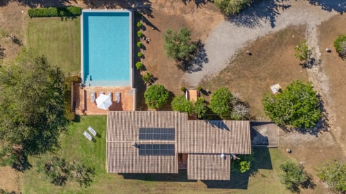 Vista aérea de Massa Properties en Artà con piscina rectangular, tejados de terracota, paneles solares y jardines cuidados