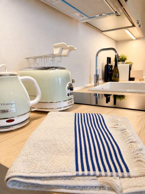 Modern kitchenette in Tuscan Townhouse Bellavista Suite with vintage appliances and blue striped kitchen towel