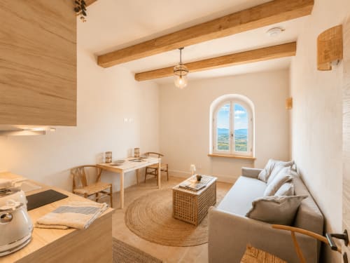 Bellavista Suite at Tuscan Townhouse: bright open-plan apartment with exposed wooden beams, arched window overlooking