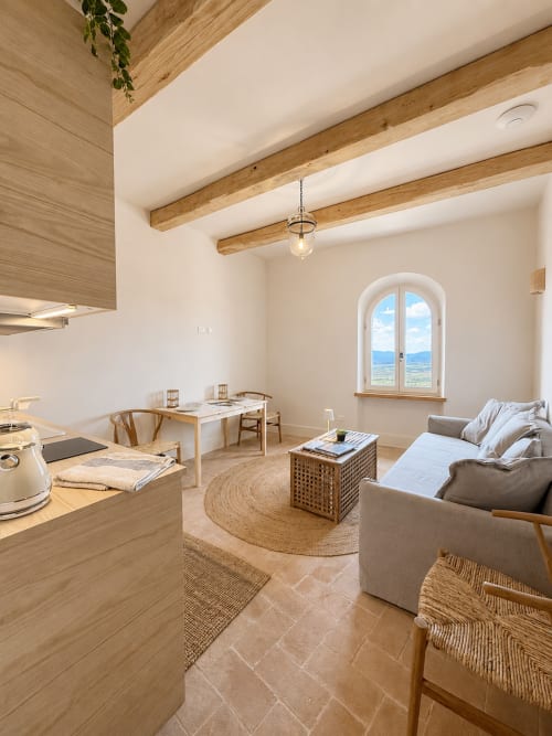 Bellavista Suite at Tuscan Townhouse in Montemassi: bright open-plan apartment with wooden beams, sofa, dining table, arched