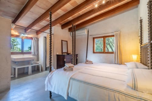 Amplio dormitorio en Massa Properties, Artà, con camas gemelas, vigas de madera y baño privado con vistas
