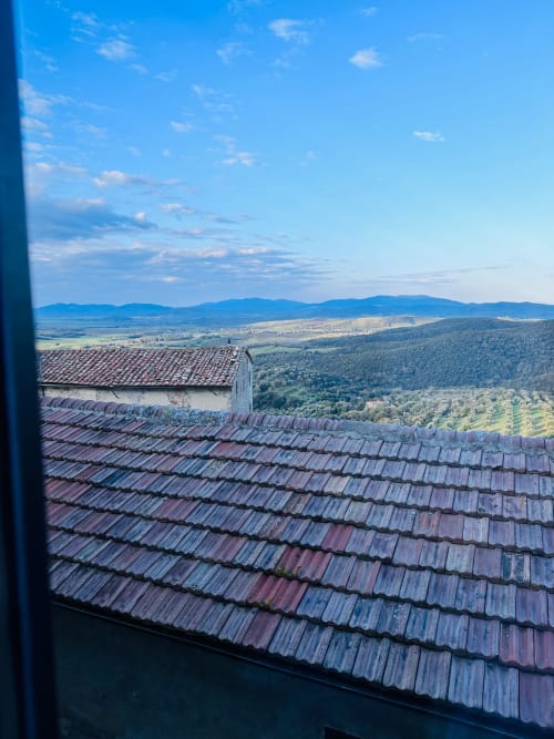 Tuscan countryside view from Bellavista Suite at Montemassi, terracotta roof tiles overlooking valleys and mountains