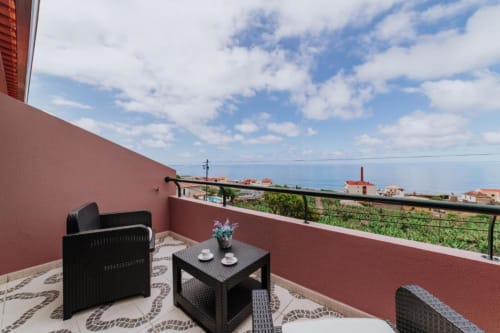 Terraço privado da Villa Amore com vista para o oceano e montanhas, com mobiliário externo preto e vista para o mar