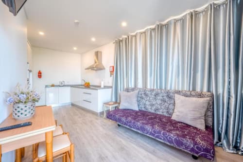 Cozinha moderna e sala de estar com vista para o mar na Villa Amore em Paul do Mar, com armários brancos, sofá com