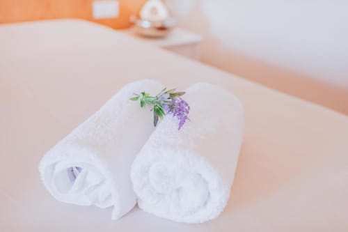 Toalhas brancas enroladas com ramo de lavanda na Villa Amore Accommodation, uma hospedaria portuguesa