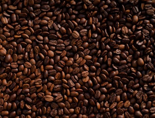 Grains de café torréfiés foncés, parfaits pour votre café du matin à Balaga Vacances, gîte de charme à Sainte-Anne, Guadeloupe