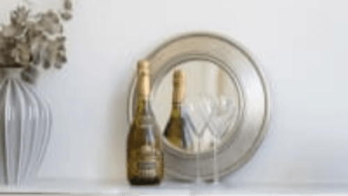 Bouteille de vin et verres avec assiette dans un intérieur moderne à Secrets de Chef de Cave, Reims