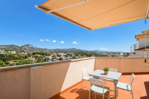 Soleada terraza con vistas a la montaña en Riurau Home Calpe, con mesa de comedor, toldo retráctil