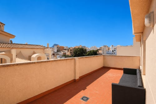 Amplia terraza del apartamento Riurau Home en Calpe con baldosas de barro, vistas a las montañas y el paisaje urbano