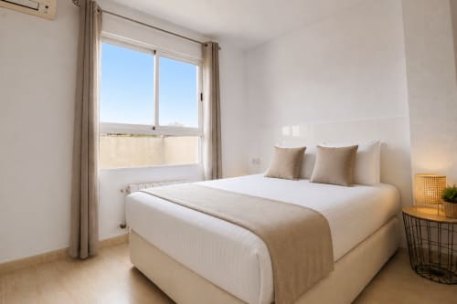Dormitorio luminoso en Riurau Home, Calpe, con cama queen, balcón con vista a montañas y comodidades modernas