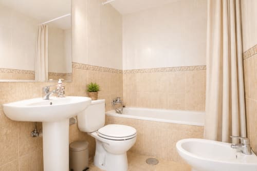 Baño espacioso en apartamento Riurau Home, Calpe con bañera, inodoro, lavabo de pedestal y ducha