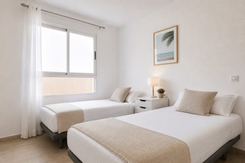 Luminoso dormitorio doble en el apartamento Riurau Home de Calpe con camas modernas, ropa de cama blanca, vistas a la montaña y decoración minimalista