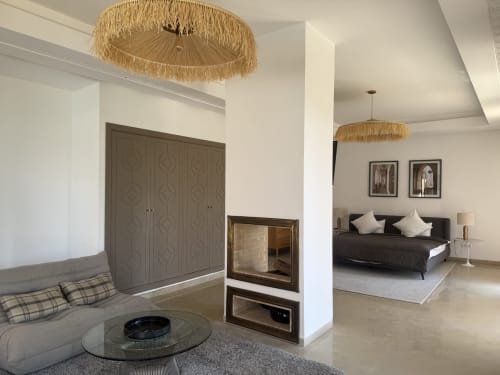 Suite luxueuse à la Villa Rêve D'ahlam à Jbilate avec cheminée, mobilier moderne et luminaire au plafond tressé