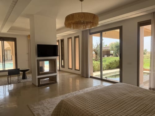 Chambre luxueuse spacieuse à la Villa Rêve D'ahlam à Jbilate avec cheminée moderne et portes-fenêtres donnant sur les jardins
