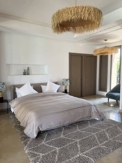 Chambre principale moderne de la Villa Rêve D'ahlam à Jbilate avec luminaires tressés, décoration épurée et portes panoramiques