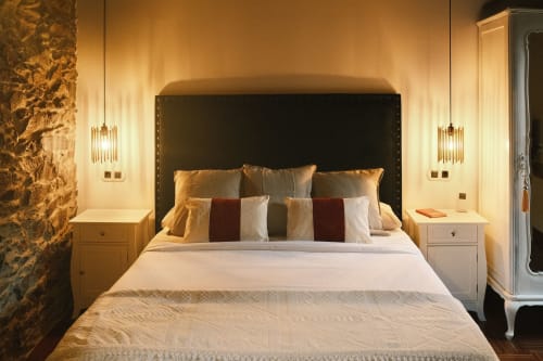 Lujosa habitación de Casa Grande de Covas con cabecero oscuro, almohadas doradas e iluminación elegante en Taboada