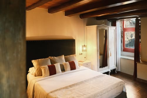Elegante dormitorio en Apartamento Camelia de Casa Grande de Covas, Taboada, con vigas de madera, cabecero negro y vistas al río