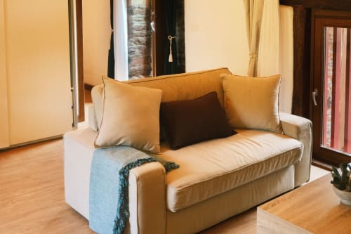 Sofá beige con cojines decorativos en Apartamento Cerezos del hotel de lujo Casa Grande de Covas, Taboada