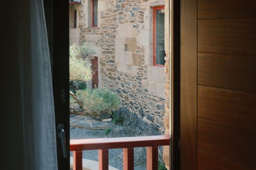 Vista desde el apartamento Casa Grande de Covas con patio de piedra, barandilla roja y arquitectura tradicional gallega