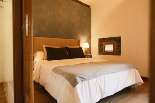 Dormitorio moderno en Apartamento Cerezos de Casa Grande de Covas, Taboada con cama queen, cabecero naranja e iluminación cálida