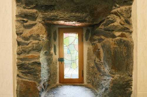 Puerta de madera con vitral enmarcada por muros de piedra rústica en Casa Grande de Covas, Taboada Lugo