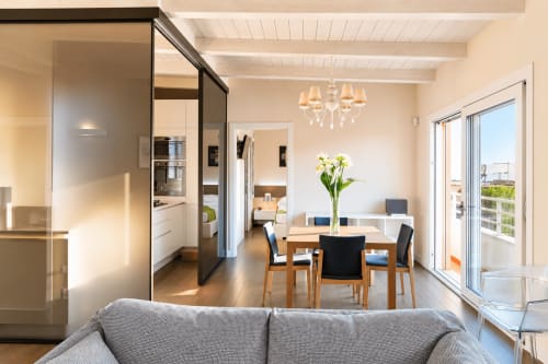 Appartamento moderno open-plan a Reggio Calabria con vista mare, zona pranzo, cucina e accesso al balcone.