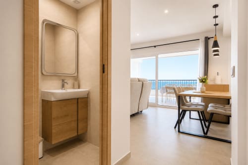 Lavabo moderno con mueble de madera en apartamento Calpe Playa con vistas al mar de Riurau Home