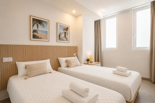 Dormitorio doble luminoso en apartamento Riurau Home, Calpe con vistas al mar, camas gemelas, cabecero de madera y arte marino
