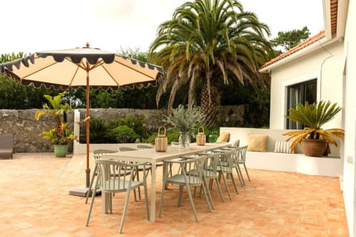 Sea'Ya Casa Pavão villa terrace in Colares with dining table, cream umbrella, and palm trees overlooking the garden