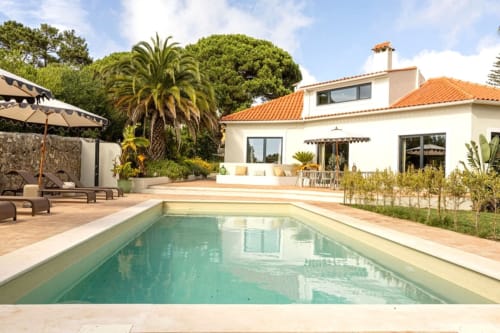 Sea'Ya Casa Pavão villa in Colares with private pool, terracotta patio, palm trees, and modern white villa architecture