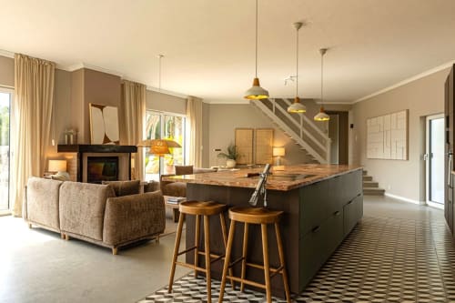 Modern open-plan living area at Sea'Ya Casa Pavão villa in Colares with kitchen island, fireplace, and pendant lighting