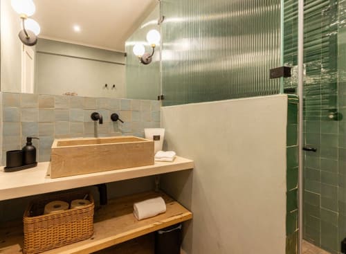 Modern bathroom at Sea'Ya Casa Pavão villa in Colares with wooden sink, green tile shower, and ambient lighting