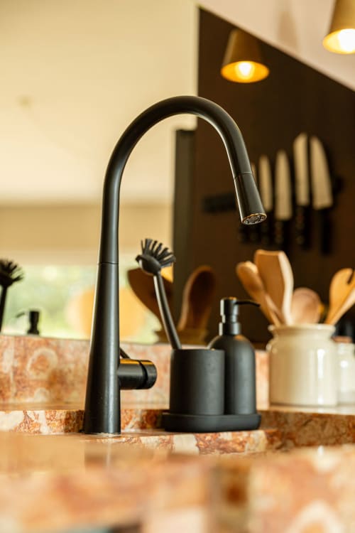 Modern black kitchen faucet with wooden utensils at Sea'Ya Casa Pavão villa in Colares
