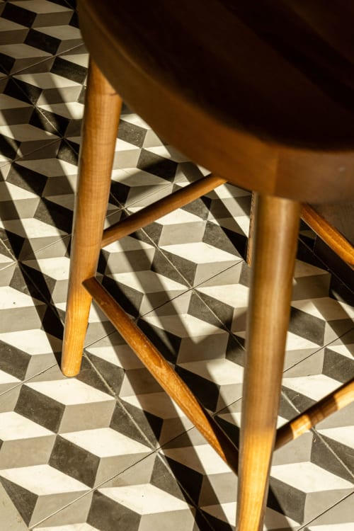 Wooden chair legs on geometric patterned floor at Sea'Ya Villas villa in Colares, Portugal