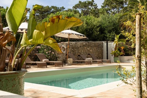 Sea'Ya Casa Pavão villa pool with turquoise water, loungers, umbrella, and lush garden in Colares, Portugal
