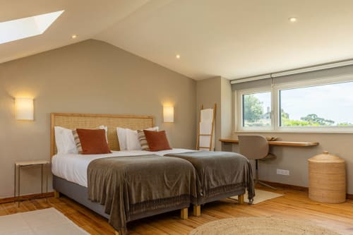 Spacious bedroom at Sea'Ya Casa Pavão villa in Colares with two beds, wooden headboard, natural lighting, and mountain views