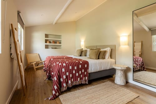 Spacious bedroom at Sea'Ya Casa Pavão villa in Colares with king bed, burgundy throw, mirror, and wooden accents