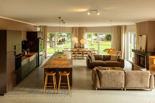 Open-plan living area in Sea'Ya Casa Pavão villa, Colares, with kitchen, dining table, sofas, and garden views